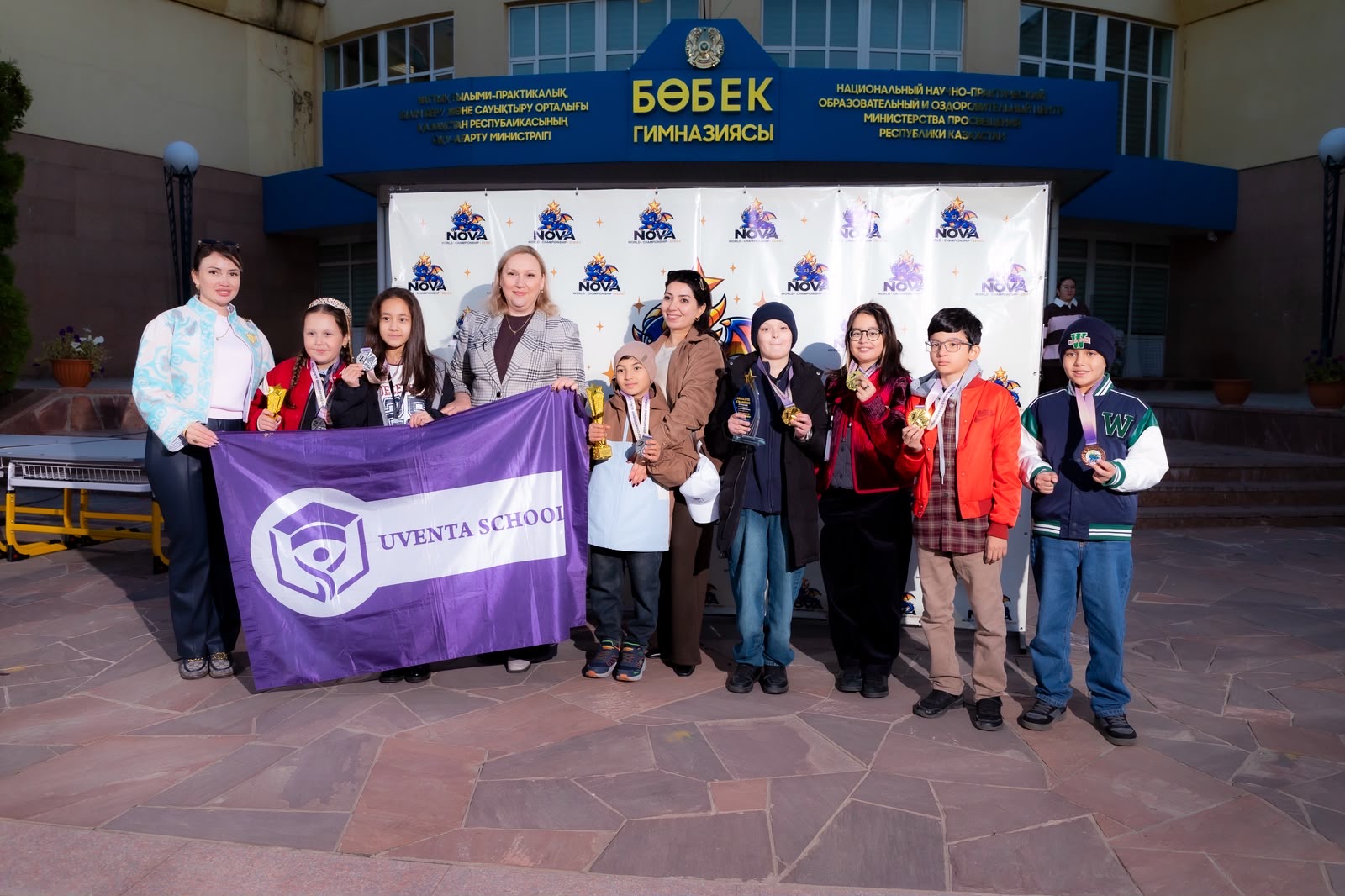 Students holding awards outside a school in Almaty